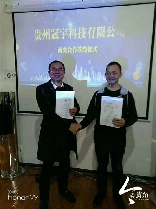 2     贵州冠宇科技有限公司总裁李大国（左）与加盟商合影留念.jpg